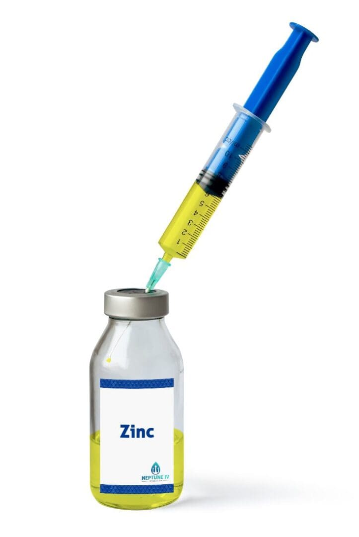 A syringe drawing a liquid from a vial labeled zinc, suggesting the preparation of a zinc and vitamins supplement for injection.