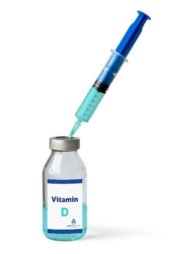 A syringe, part of a mobile iv therapy setup, extracting a dose from a small bottle labeled "vitamin D.
